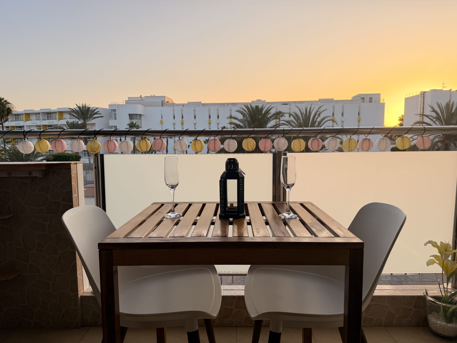 Apartment Two's terrace at sunset, with a table and glasses