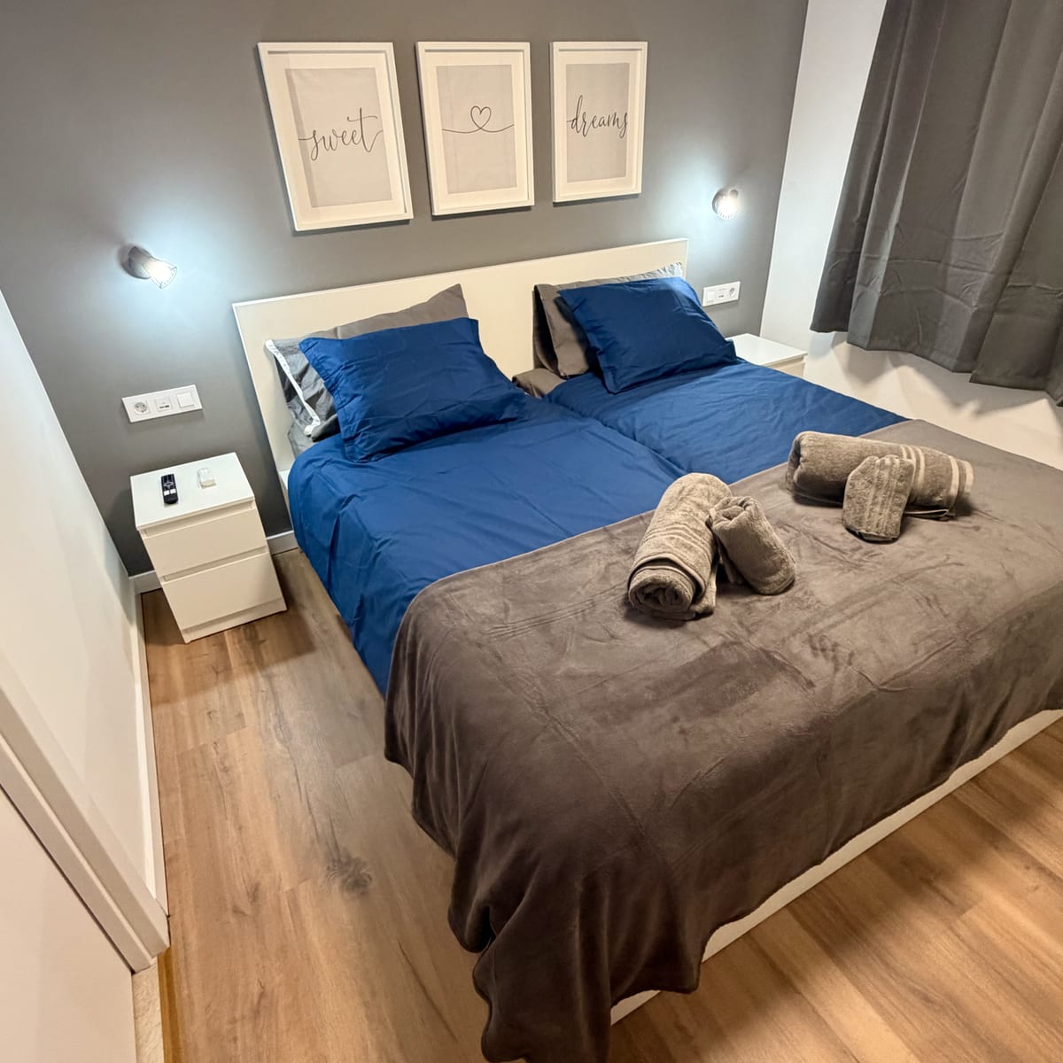 Apartment Two's main bedroom, with headboard and framed prints