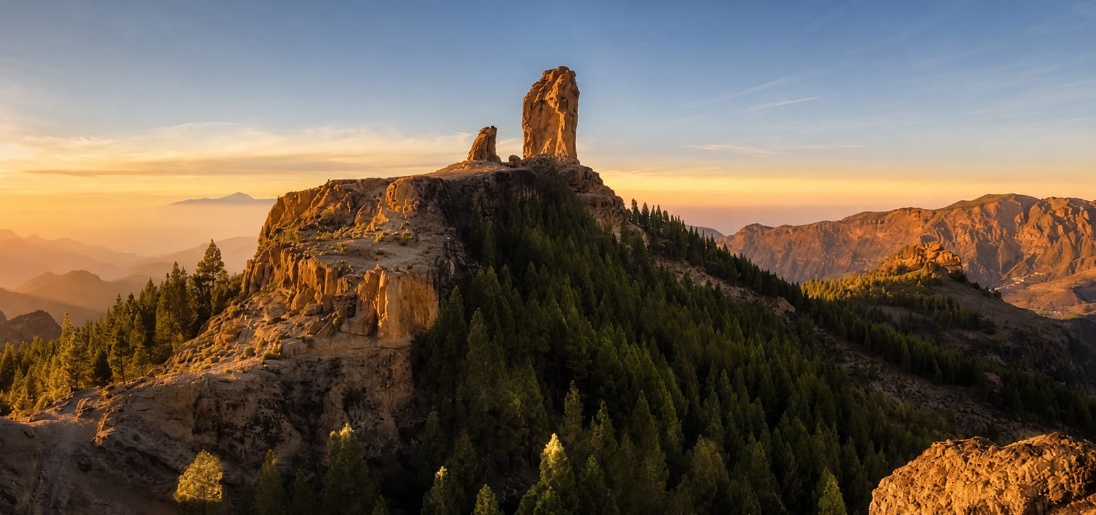 Rock formations and pine-covered slopes at sunset
