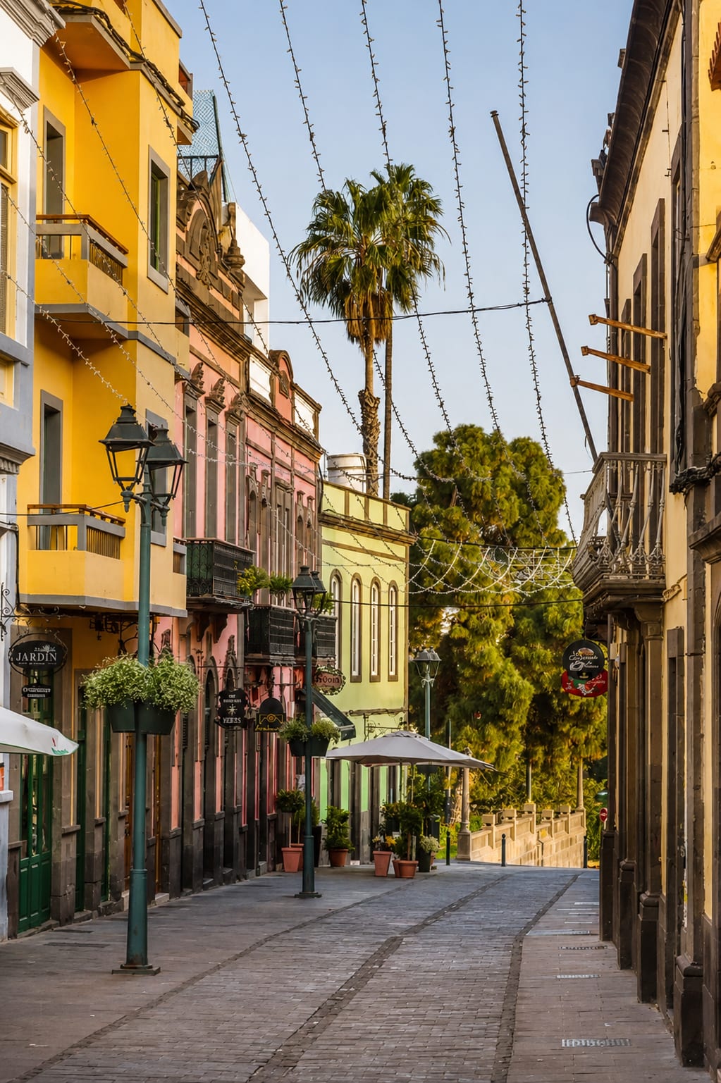 Colourful street with balconies, palm trees and lights